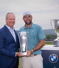 PGA TOUR pro Scottie Scheffler poses with Sebastian Mackensen, President and CEO, BMW of North America, with the BMW Championship Trophy and J.K. Wadley Trophy following his win at the 2024 BMW Championship at Caves Valley Golf Club in Owings Mills, MD on Sunday, August 17, 2025. All proceeds from the BMW Championship benefits the Evans Scholars Foundation which provides full college scholarships to deserving young caddies./WGA/Charles Cherney