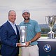 PGA TOUR pro Scottie Scheffler poses with Sebastian Mackensen, President and CEO, BMW of North America, with the BMW Championship Trophy and J.K. Wadley Trophy following his win at the 2024 BMW Championship at Caves Valley Golf Club in Owings Mills, MD on Sunday, August 17, 2025. All proceeds from the BMW Championship benefits the Evans Scholars Foundation which provides full college scholarships to deserving young caddies./WGA/Charles Cherney