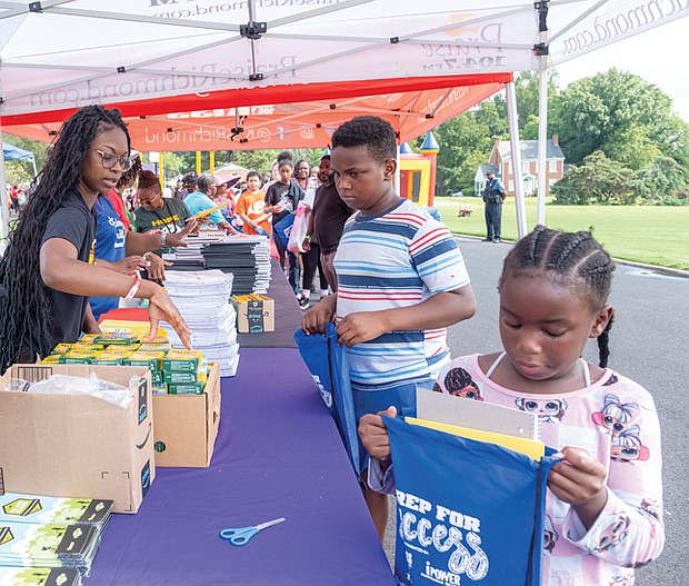 Unique Bolden, 6, checks her school supply bag while her cousin, Jeremiah Richardson, waits his turn at Speaking Spirit Ministries in Richmond on Saturday, Aug. 16, for Urban One Inc.’s Prep for Success Back to School Bash, receiving free supplies and community resources.