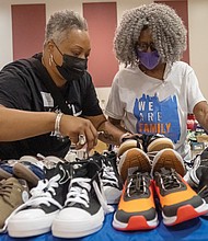 Volunteers Kim Allen and Willnette Beard browse shoes for student shoppers at the 19th annual New Shoes for Back to School event organized by the Metropolitan Richmond Partnership of Churches/Synagogues with participants from congregations across the area gave Richmond-area students new shoes to start the school year. Families lined up at a local church to pick shoes by size, enjoy live music, and take part in a voter registration drive.