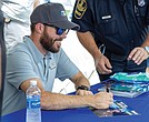 Ross Chastain, NASCAR Cup Series driver, signs autographs at Richmond Raceway on Aug. 15 during the “Who’s Your Driver?” fan event with the Virginia DMV and Drive Smart Virginia.