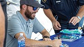 Ross Chastain, NASCAR Cup Series driver, signs autographs at Richmond Raceway on Aug. 15 during the “Who’s Your Driver?” fan event with the Virginia DMV and Drive Smart Virginia.