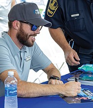 Ross Chastain, NASCAR Cup Series driver, signs autographs at Richmond Raceway on Aug. 15 during the “Who’s Your Driver?” fan event with the Virginia DMV and Drive Smart Virginia.