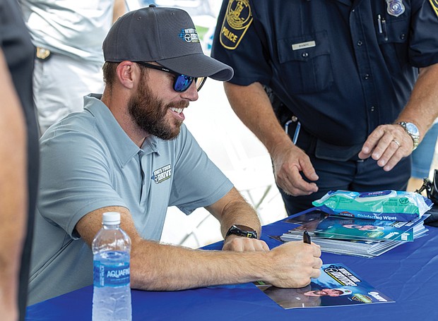 Ross Chastain, NASCAR Cup Series driver, signs autographs at Richmond Raceway on Aug. 15 during the “Who’s Your Driver?” fan event with the Virginia DMV and Drive Smart Virginia.