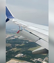 A still from a video taken aboard a Delta flight, on August 19, shows a flap dangling behind a wing of the plane.
Mandatory Credit:	Shanila Arif via CNN Newsource