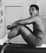 Muhammad Ali sits on a table in Miami in 1970.