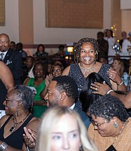 Kelly Jackson and Ammie Derricott, owners of Around The Table LLC, head to the stage to accept the Rising Community Impact Award at the BLK RVA Community Awards.