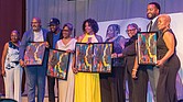 Award winners pose on stage at the Hippodrome. Pictured left to right: Evette Roots, vice president and senior social impact and sustainability specialist, Wells Fargo; Micheal Sparks, CEO of The Underground Kitchen; JP Mines and his mother, Pam Mines, founder of the JP JumPers Foundation; Shakia Gullette Warren, executive director of the Black History Museum & Cultural Center of Virginia; Ammie Derricott and Kelly Jackson, owners of Around The Table LLC; James Crump-Wallace, founder of Celebration of Black Music in Film; and host Clovia Lawrence, community outreach director for Radio One Inc.