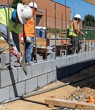 Masonry workers lay a cinder block wall outside the new Richmond High School for the Arts, a $140 million facility currently under construction. The school, designed to serve about 1,800 students, will offer specialized spaces for dance, music, video production and other creative programs, giving students modern tools to develop their talents.Officials say the project is on track for completion in winter 2026.