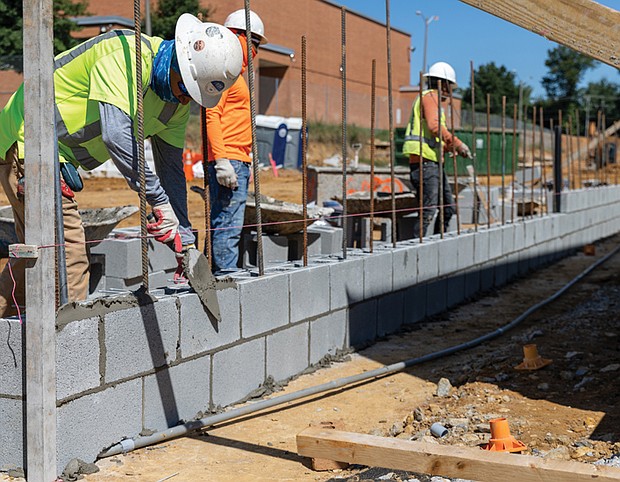 Masonry workers lay a cinder block wall outside the new Richmond High School for the Arts, a $140 million facility currently under construction. The school, designed to serve about 1,800 students, will offer specialized spaces for dance, music, video production and other creative programs, giving students modern tools to develop their talents.Officials say the project is on track for completion in winter 2026.