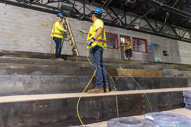 Construction workers install wiring in the soon to be auditorium of the new Richmond High School for the Arts, a $140 million project under construction off Midlothian Turnpike. The school will accommodate about 1,800 students and offer facilities for programs including dance, music and video production. Completion is expected in winter 2026.