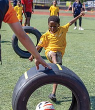 Ahmel, 5, kicks a ball through a race car tire at a soccer clinic Friday, Aug. 15, at the Boys & Girls Clubs of Metro Richmond on Bainbridge Street in South Side.