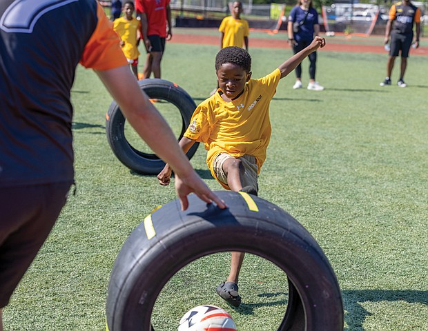 Ahmel, 5, kicks a ball through a race car tire at a soccer clinic Friday, Aug. 15, at the Boys & Girls Clubs of Metro Richmond on Bainbridge Street in South Side.