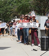 Protesters hold signs outside Richmond City Hall on Aug. 11 during a rally against recent Immigration and Customs Enforcement detentions, urging
the city to block local cooperation with federal immigration authorities.