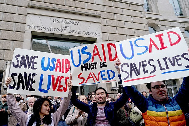 People hold placards, as the USAID building sits closed to employees after a memo was issued advising agency personnel to work remotely, in Washington, D.C., U.S., February 3.
Mandatory Credit:	Kent Nishimura/Reuters via CNN Newsource