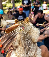 Joseph Warren (C), an Anishinaabe tribal community member, wears a traditional headdress during a Totem Pole consecration ceremony held by the House of Tear Carvers at the Shell City campground in Menahga, Minnesota on July 25, 2021.
Mandatory Credit:	Kerem Yucel/AFP/Getty Images via CNN Newsource