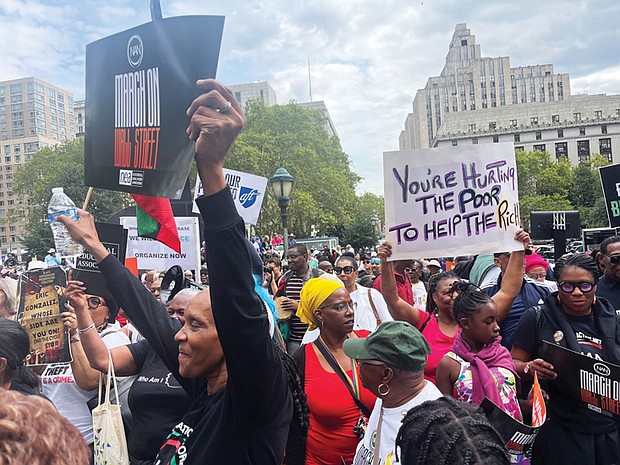 Protesters march on Wall Street in New York on Aug. 28 to denounce companies abandoning diversity, equity and inclusion initiatives. Left, The Rev.