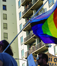 Spectators watch from Broad Street apartments as hundreds of demonstrators move through the city.