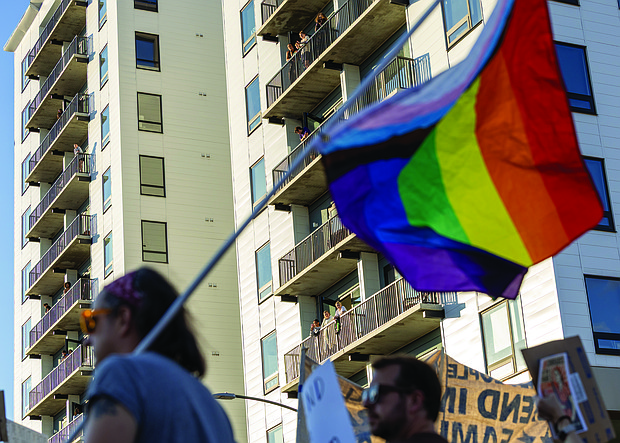 Spectators watch from Broad Street apartments as hundreds of demonstrators move through the city.