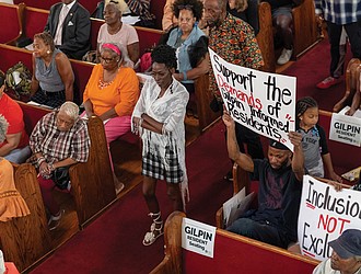 Gilpin Court resident Sylvia Davis waits in line to voice concerns about the Richmond Redevelopment and Housing Authority’s proposal to use its nonprofit arm, the Richmond Development Corporation, in the Gilpin Court community redevelopment during a discussion Thursday, Aug. 28, at Greater Mount Moriah Baptist Church.