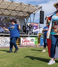 Abigail Holliday line dances to the “Salsa Slide” while wearing a Puerto Rican flag at the event.
