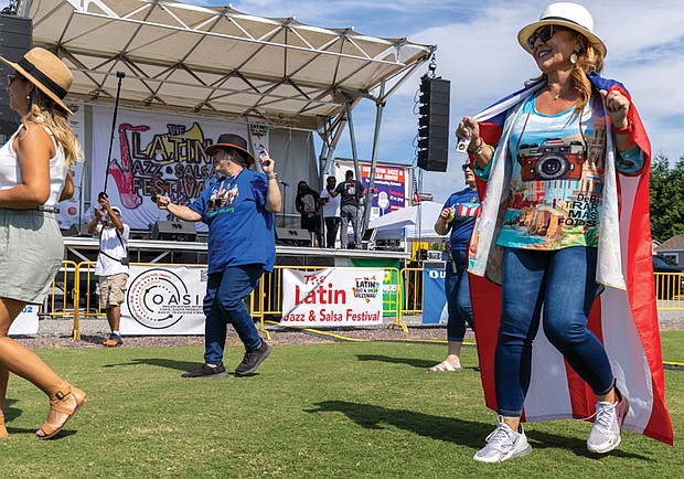 Abigail Holliday line dances to the “Salsa Slide” while wearing a Puerto Rican flag at the event.