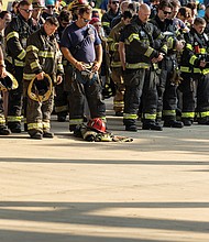 Firefighters, first responders and community members bow their heads in a moment of silence during the opening ceremony Saturday, Sept. 6 at
Richmond Raceway after completing the Metro Richmond 9/11 Memorial Stair Climb. The event honors first responders who died on Sept. 11, 2001,
and those who later died from related health complications. Participants climbed 2,200 steps, representing the 110 stories of the World Trade Center,or walked a 5K around the track. For more photos, see A3.