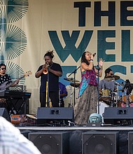 Vocalist Sam Reed performs at The WELL Fest outside of Main Street Station.