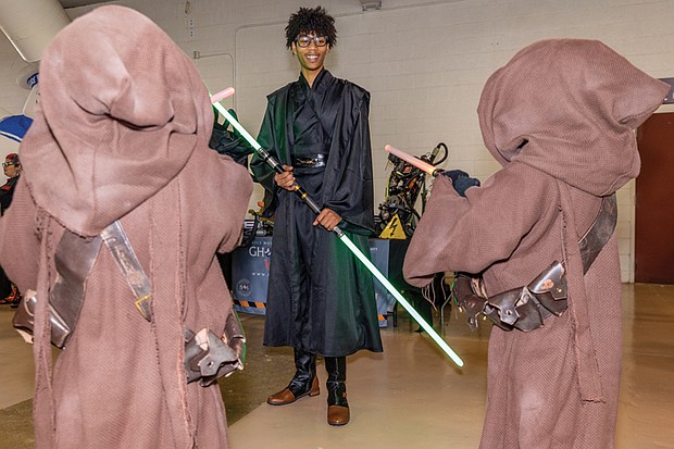 Left, Jadin Whitaker, dressed as a Sith Lord from “Star Wars,” meets two young Jawas,the hooded scavenger characters from the Star Wars universe, at the raceway.