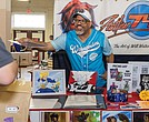 Richmond comic artist Will Watkins sells and signs artwork for a customer during the ComiCon. The artist is known for his dynamic digital illustrations and vibrant character designs.