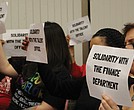 RPS employees hold signs in support of colleagues who filed complaints
during a Richmond School Board meeting Feb. 4.