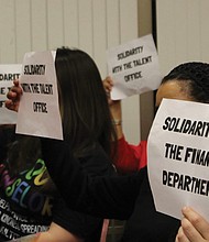 RPS employees hold signs in support of colleagues who filed complaints
during a Richmond School Board meeting Feb. 4.