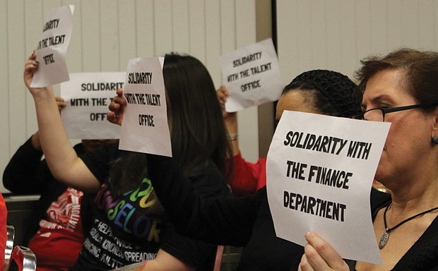 RPS employees hold signs in support of colleagues who filed complaints
during a Richmond School Board meeting Feb. 4.