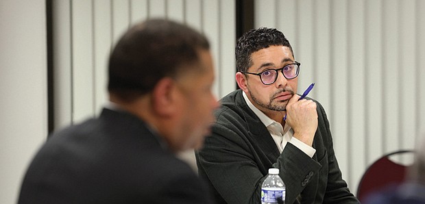 Kyle Elliott, a member of the RRHA Board of Commissioners, listens as Steven Nesmith discusses a resolution he introduced for a vote during the RRHA Board of Commissioners meeting on Wednesday night, Sept. 17. Elliott voiced opposition to voting on the resolution during the meeting.