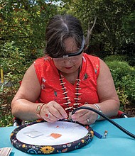 Native Arts Shine at Lewis Ginter-The inaugural Kennanee Native Arts Festival brought Indigenous art, culture and community to Lewis Ginter Botanical Garden on Sunday. Created with the Virginia Native Arts Alliance and Indigenous voices from across the East Coast, the festival featured music, storytelling, crafts, seed-saving, short films, a live Shinny game and an arts market. Tamsye Stover of The Chickahominy Beaded Turtle uses the Peyote stitch method to bead a stethoscope. (Sandra Sellars/Richmond Free Press)