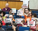 During the City Council’s public comment period at City Hall on Monday, Sept. 22, residents hold up signs calling for more affordable housing and stronger protections against rent gouging.