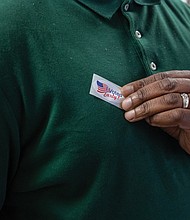 An early voter claims a souvenir at the Eastern Henrico voting location on Nine Mile Road. Right, on Friday, Sept. 19