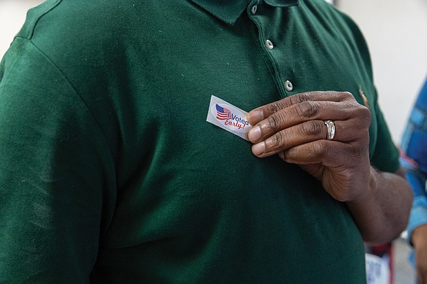 An early voter claims a souvenir at the Eastern Henrico voting location on Nine Mile Road. Right, on Friday, Sept. 19
