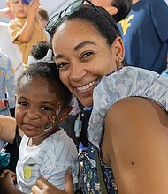Music, food and beer flow at Oktoberfest- It wasn’t quite October, but Richmonders came out to the Museum District on Friday, Sept. 19, for the 20th annual St. Benedict’s Oktoberfest. The three-day festival features live music and dancing, a Christkindlmarkt, children’s activities, German food and beers from Germany and local breweries. 2-year-old Berkeley Jones and her mother, Lauren Jones, enjoy live music at the event.(Julianne Tripp Hillian/Richmond Free Press)