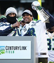 Russell Wilson holds the Lombardi Trophy at CenturyLink Field. Wilson won the 2014 Super Bowl with Seattle and has embarked upon his 14th NFL season. He became the first Black quarterback in New York Giants history
to start a season opener and was recently named the National Black Players Coalition’s “Quarterback of the Century” for his on- and off-field achievements.