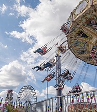 State of fun
The State Fair of Virginia returned to The Meadow Event Park in Doswell last weekend, drawing crowds from across the Commonwealth and beyond.
Fairgoers packed the midway, sampling food from vendors, testing their luck at carnival games and taking in the rides. The fair, which
opened Sept. 26, continues through Oct. 5. Fair skies-Riders soar on the Wave Swinger at the State Fair of Virginia in Doswell, where thousands from across the state gather for food, games and rides. (Sandra Sellars/Richmond Free Press)