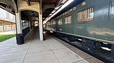 Side view of Railcar ONE on display at the Science Museum of Virginia, with the boarding hall visible beside it.