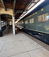 Side view of Railcar ONE on display at the Science Museum of Virginia, with the boarding hall visible beside it.