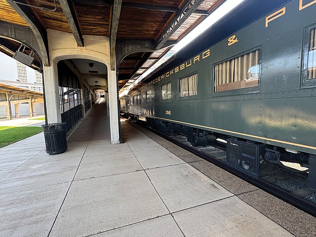 Side view of Railcar ONE on display at the Science Museum of Virginia, with the boarding hall visible beside it.