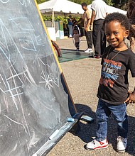 Fun first at Second-Street Festival-The 2nd Street Festival marked its 37th anniversary Oct. 4-5, filling Richmond’s historic Jackson Ward with
music, food and community spirit. The annual event celebrates the culture and legacy of Jackson Ward — once known as “the Harlem of the South” — and the neighborhood’s role as the heart of Richmond’s Black community. The free festival featured three stages of live entertainment, a Kidz Zone, food vendors, an Artists Row, and a marketplace showcasing local talent
and craftsmanship. Hameen Hurling Jr, 4, showcases his creative talents on a chalkboard in the kids area at the event. (Julianne Tripp Hillian/Richmond Free Press)