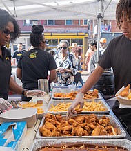 Fun first at Second-Street Festival-The 2nd Street Festival marked its 37th anniversary Oct. 4-5, filling Richmond’s historic Jackson Ward with music, food and community spirit. The annual event celebrates the culture and legacy of Jackson Ward — once known as “the Harlem of the South” — and the neighborhood’s role as the heart of Richmond’s Black community. The free festival featured three stages of live entertainment, a Kidz Zone, food vendors, an Artists Row, and a marketplace showcasing local talent and craftsmanship. Brianna Royal and Davin Washington Jr. serve fried treats to a long line of customers at the Croaker’s Spot tent. (Julianne Tripp Hillian/Richmond Free Press)