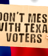 The phrase " Don’t mess with Texas voters " on a banner in men's hand with blurred Texans flag on the background. Fraud. Laws. Voice. Survey. News. Nation. Duty. Citizen. Bulletin. System. Texan