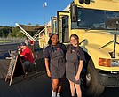 Addison Bryce, left, and Alexis Phillips stand in front of the Dawg Treats food bus at Goochland High School, where they sell globally inspired cuisine during football games.