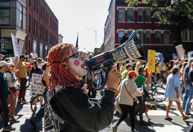 A demonstrator in clown makeup rallies the crowd with a bullhorn on Broad Street in Richmond during the No Kings protest. (Julianne Tripp Hillian/Richmond Free Press)