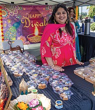 Festival highlights traditional Indian arts and dance-Richmond celebrated Indian culture and traditions at the Diwali Music & Arts Festival on Oct. 18 at the Virginia Museum of History & Culture. The event, hosted in collaboration with The Rith Initiative, featured classical and folk dances, a Ramayan puppet show, a “Drapes of India” fashion show, henna and rangoli stations, and an arts bazaar highlighting local artisans. Ritu Buhargava of Desi Sparkles offers tasty treats at the festival. (Julianne Tripp Hillian/Richmond Free Press)